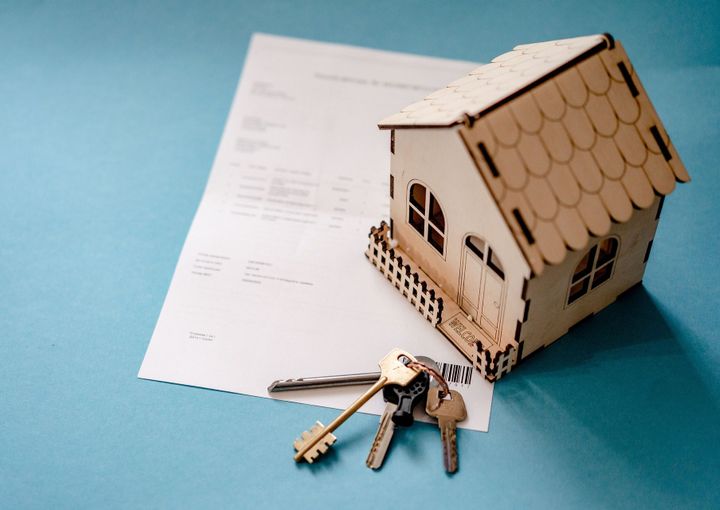Une petite maison avec un contrat et des clefs